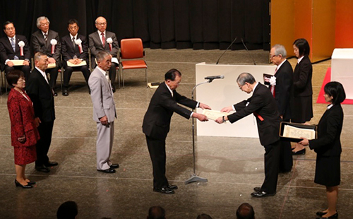 交通栄誉章受賞代表者に金髙雅仁警察庁長官から表彰状が、今井敬会長から交通栄誉章が贈られた